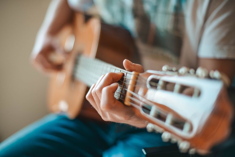 Mãos tocando violão de perto